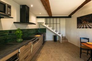 a kitchen with wooden cabinets and a staircase at Maison de village Luberon in Lauris