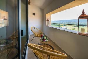 a room with two chairs and a balcony with a view at Maison de village Luberon in Lauris