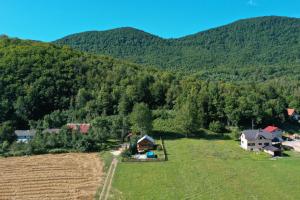 une vue aérienne sur une ferme avec des montagnes en arrière-plan dans l'établissement Stara trešnja, à Smiljan