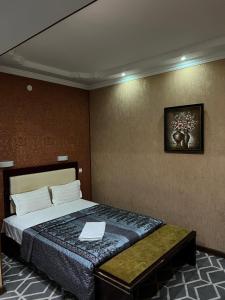 Sary Arka Hotel في شيمكنت: غرفة في الفندق مع سرير مع لاب توب عليه