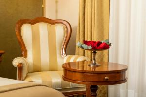 uma mesa e uma cadeira com uma tigela de rosas em Hotel Niko em Zadar