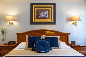 sypialnia z łóżkiem z niebieskimi poduszkami w obiekcie Hotel Niko w mieście Zadar
