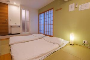 a room with a bed in a room with a window at Miro Hotel Momodanikoen-mae in Osaka