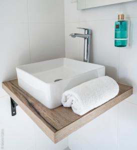 baño con lavabo blanco en una estantería de madera en 26 Faubourg - Ex-Hotel de Reims, en París