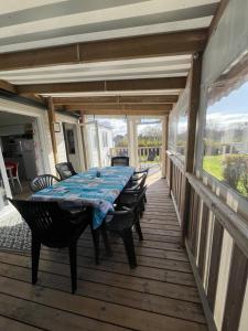 a wooden deck with a table and chairs on it at MH VAL&YVAN plage, piscine pointe de Trévignon et concarneau in Trégunc