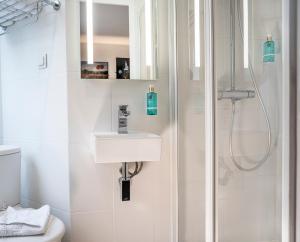 y baño con lavabo y ducha. en 26 Faubourg - Ex-Hotel de Reims, en París