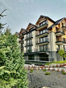 a large apartment building with a christmas tree in front of it at Kazalnica Family&Conference Resort in Sosnówka
