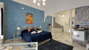 a bedroom with a bed and a blue wall at GL Golden City Apartments in Catania