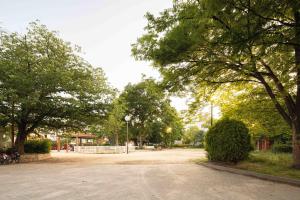 a park with trees and a dirt road at Miro Hotel Momodanikoen-mae in Osaka