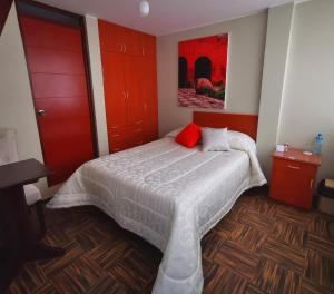 1 dormitorio con 1 cama con armarios rojos y una pintura en Bon Repos Arequipa, en Arequipa