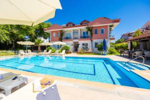 a villa with a swimming pool and a house at Safak Oasis Hotel in Dalyan