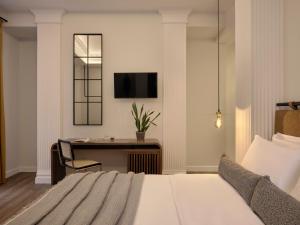 um quarto de hotel com uma cama e uma secretária em Astikon House em Atenas