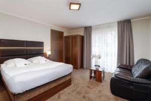 una camera d'albergo con letto e sedia di Hotel SPA Activia a Jastrzębia Góra
