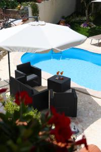 einen Tisch und einen Sonnenschirm neben einem Pool in der Unterkunft Casita GioJa in Gasponi