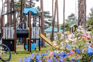a playground in a park with flowers at FOREST Family Resort Ustka in Ustka