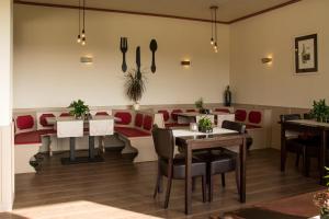 a dining room with tables and red chairs at Landhaus Eifelsicht in Hellenthal