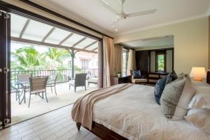 a bedroom with a large bed and a balcony at Maison L'Amirale by Simply-Seychelles in Eden Island