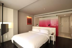sypialnia z dużym białym łóżkiem i telewizorem w obiekcie Metropolo Classiq Dahua Hotel Shanghai Jing'an w Szanghaju