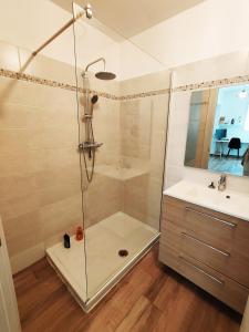 een douche met een glazen deur naast een wastafel bij Appartement 80 m2 avec jardin - 50m de la plage TIKI in Saint-Raphaël +20 foto's