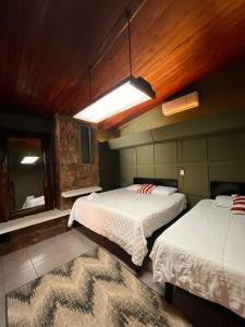 sypialnia z 2 łóżkami i dużym lustrem w obiekcie VILLA NAPOLI w mieście Santa Ana