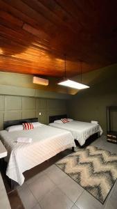 a bedroom with two beds and a wooden ceiling at VILLA NAPOLI in Santa Ana