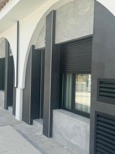 a building with black shutters on the side of it at Apartamentos Arcos de Montemar in Torremolinos