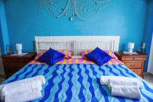 a blue bedroom with a bed with blue walls and blue pillows at 8 posti letto con parcheggio - La Flacca in Gaeta