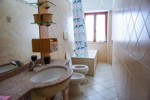 a bathroom with a sink and a toilet at 8 posti letto con parcheggio - La Flacca in Gaeta +27 photos
