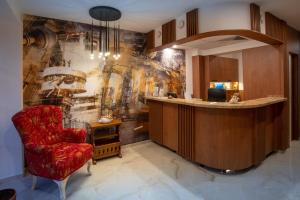a lobby with a bar and a red chair at Family Hotel Berlin Beach Sveti Vlas in Sveti Vlas