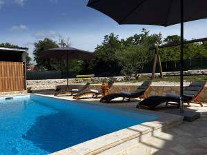 basen z leżakami i parasolem w obiekcie Holiday Home Maslina w mieście Stankovci