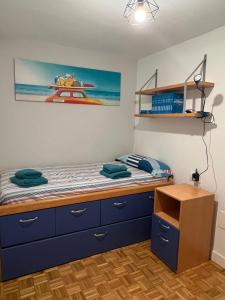 - une chambre avec un lit doté de tiroirs bleus et d'une étagère dans l'établissement Piso playa Gijon, à Gijón