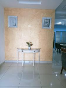 una mesa con una maceta en la pared en MR OT HOMESTAY ( BAITUL RAUDHAH ), en Kepala Batas