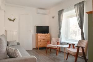 a living room with a couch and a tv at Alsóörs Pagony in Alsóörs