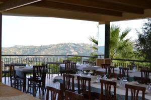 a restaurant with tables and chairs on a balcony at Il Falco del Cilento in Torchiara