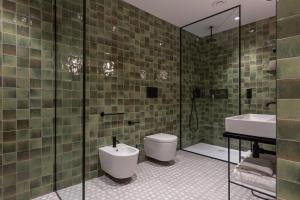 y baño con aseo, lavabo y ducha. en DuoMo Hotel en Rímini