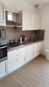 una cucina con mobili bianchi e un forno a piano cottura di Die Sonnenterrasse vom Iseosee a Tavernola Bergamasca Altre 29 foto