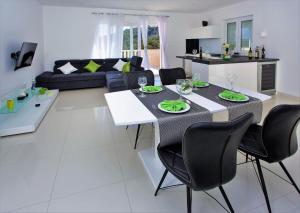 cocina y sala de estar con mesa y sillas en Villa Lokanjac, en Selca