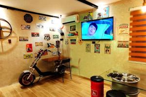 a room with a motorcycle and a tv on a wall at The Loft Elbi in Los Baños