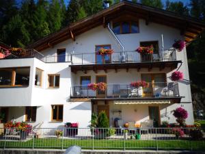 ein großes weißes Gebäude mit Blumen auf den Balkonen in der Unterkunft Pension Susanne in Sankt Anton am Arlberg