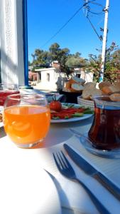 un tavolo con un piatto di cibo e un bicchiere di succo di Denge Pansiyon a Kaş