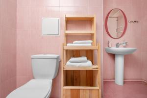 a pink bathroom with a toilet and a sink at Arzni Health Resort in Arzni