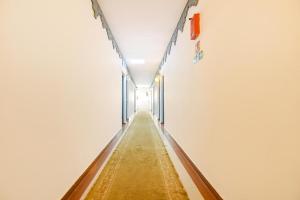 a long aisle in a white walled room at FabExpress Neo Calangute Beach Resort in Calangute