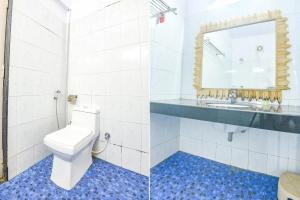 a bathroom with a toilet and a sink and a mirror at FabExpress Neo Calangute Beach Resort in Calangute