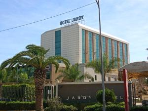 un edificio con una palmera delante de él en Hôtels Jardy en Bab Ezzouar