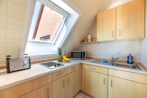 a kitchen with a sink and a window at Traumblick 3 in Utersum