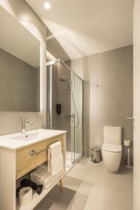 a bathroom with a sink and a shower and a toilet at Mon Suites Jardín de Ayora in Valencia