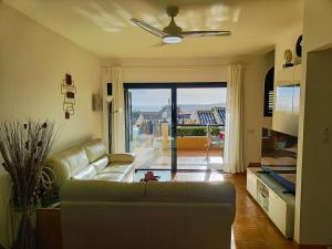 ein Wohnzimmer mit einer Couch und einem Deckenventilator in der Unterkunft Luxury House with sea view, hottub & pool in San Bartolomé de Tirajana