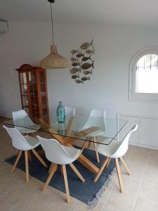 a dining room with a glass table and white chairs at Chaguimama Sea in Begur