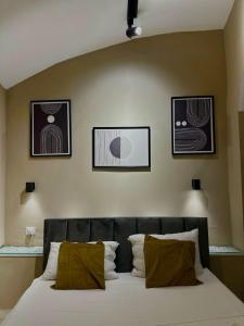 a bedroom with a bed with three pictures on the wall at Pendino Luxury Rooms in Naples