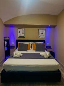 a bedroom with a large bed with blue lights at Pendino Luxury Rooms in Naples